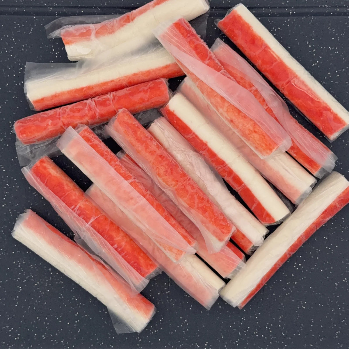 Paluszki surimi luz w osłonce, czerwono-biała struktura ułożona na stole