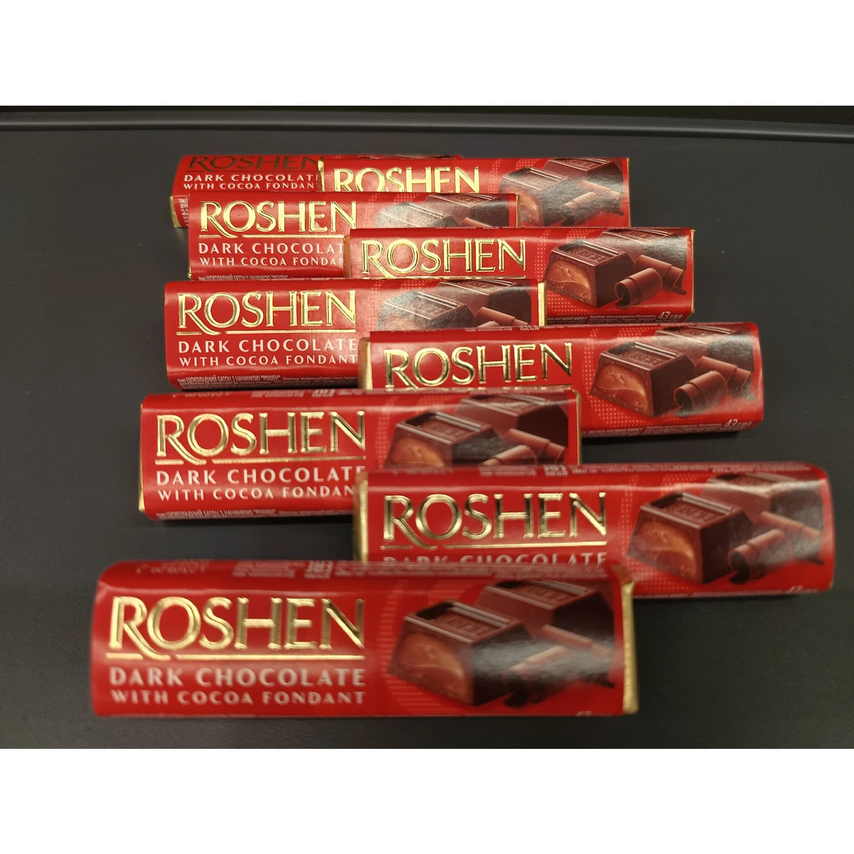 Батончики Roshen зі смаком бренді у червоних обгортках викладені рядом