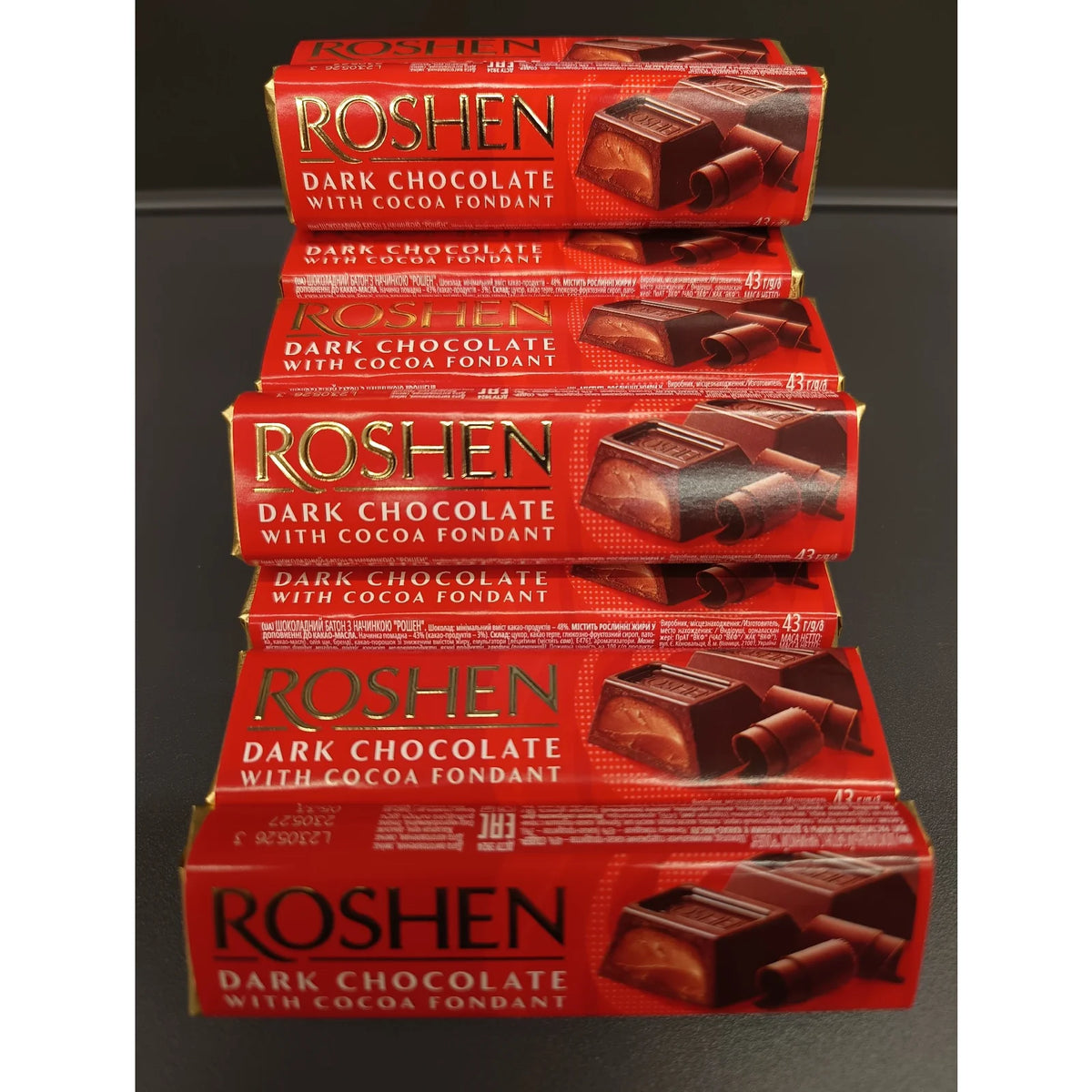 Батончики Roshen зі смаком бренді, складені один на одному, упаковки з логотипом Roshen