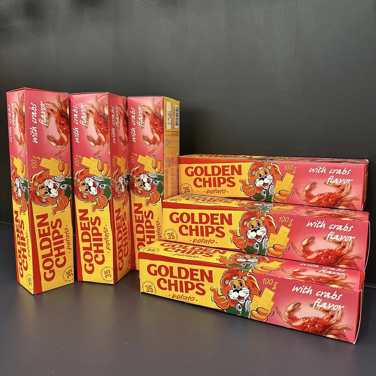 Kilka pudełek chipsów złocistych o smaku kraba, 100 g, ułożonych w rzędach