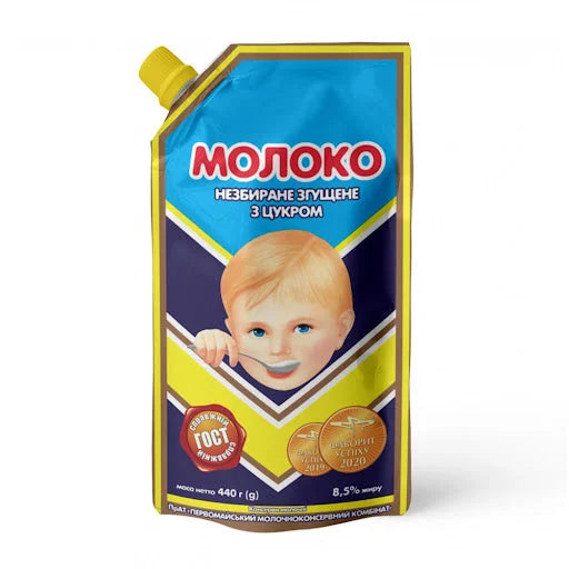 Згущене молоко Pierwomajsk 8,5% 440 г у синьо-жовтому дойпаку з жовтою кришкою та дитиною Головне фото продукту
