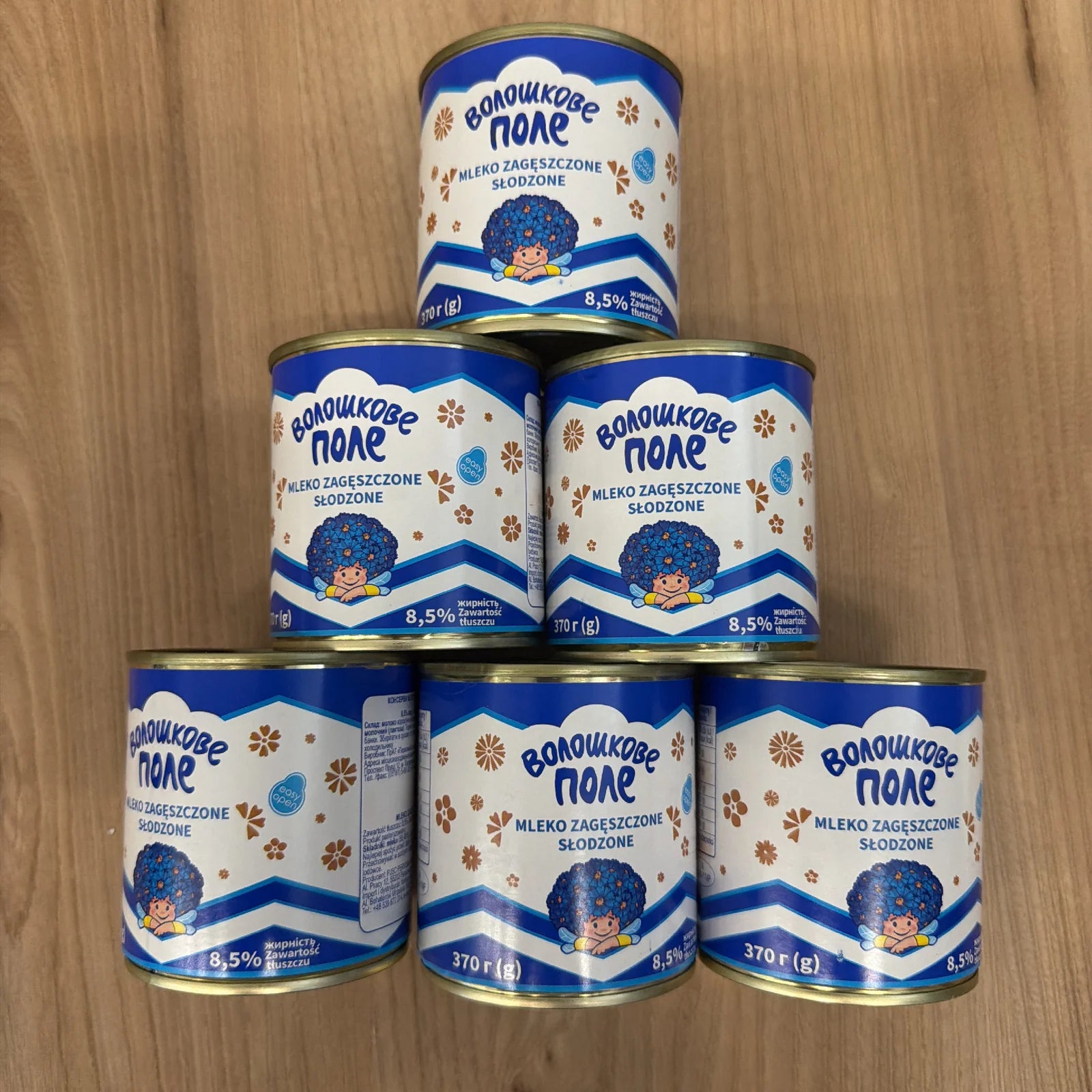 Sześć puszek mleka zagęszczonego słodzonego Voloshkove Pole 370g ułożonych w piramidę