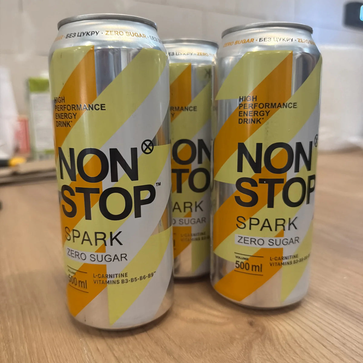 Банки енергетичного напою Non Stop Spark Zero Sugar 500мл на дерев'яній стільниці