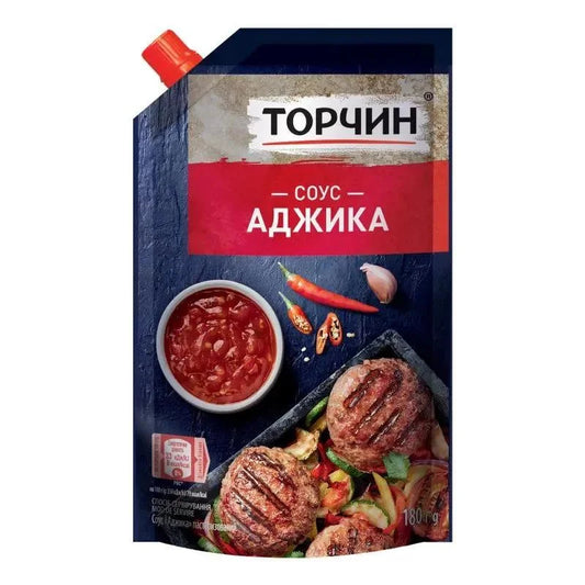 Соус аджика Торчин 180 г у темно-синьо-червоному картоні з червоною кришкою, зображення соусу, чилі й грильованого мʼяса