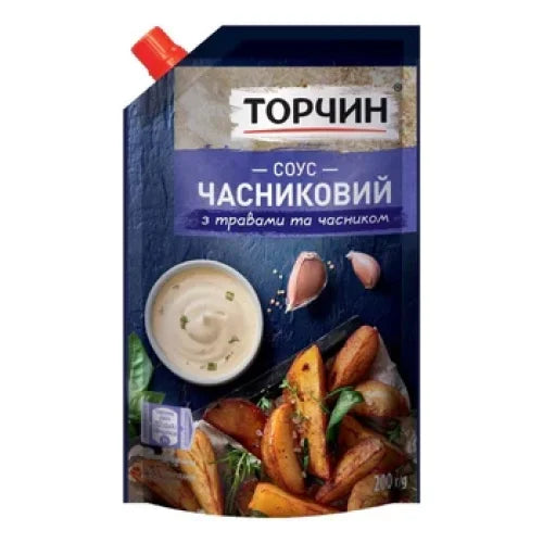 Часниковий соус Torczyn 200 г у темно-синьому картонному пакеті з червоною кришкою, з мискою соусу, часником і картоплею