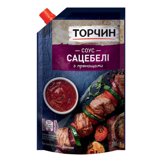 Соус сацебелі Torczyn 200 г у темно-синьо-бордовому дойпаку з червоною кришкою, шашлик і миска соусу