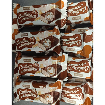 Wafelki Roshen Śliwki-Leniwki w kremowych opakowaniach na stole