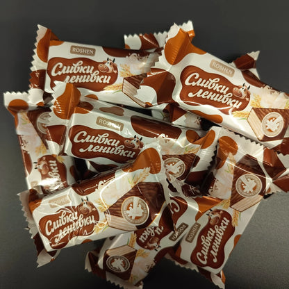 Wafelki Roshen Śliwki-Leniwki w błyszczących opakowaniach na stercie